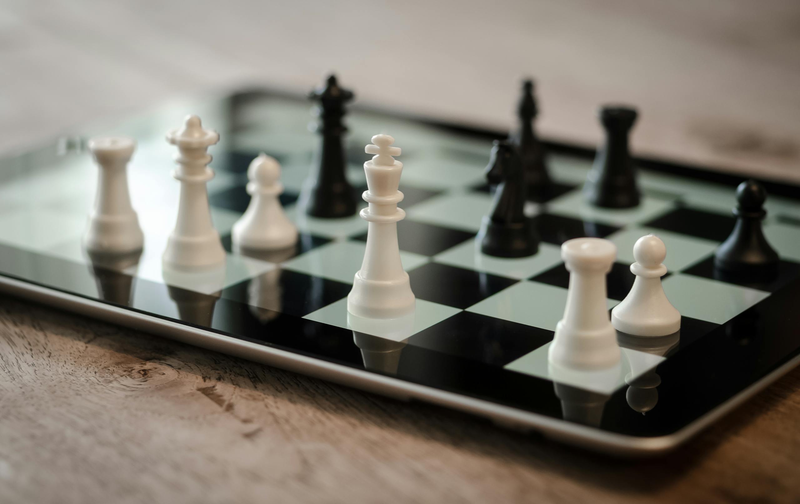 Close-up of chess game on a tablet featuring white and black pieces, emphasizing strategy and technology.
